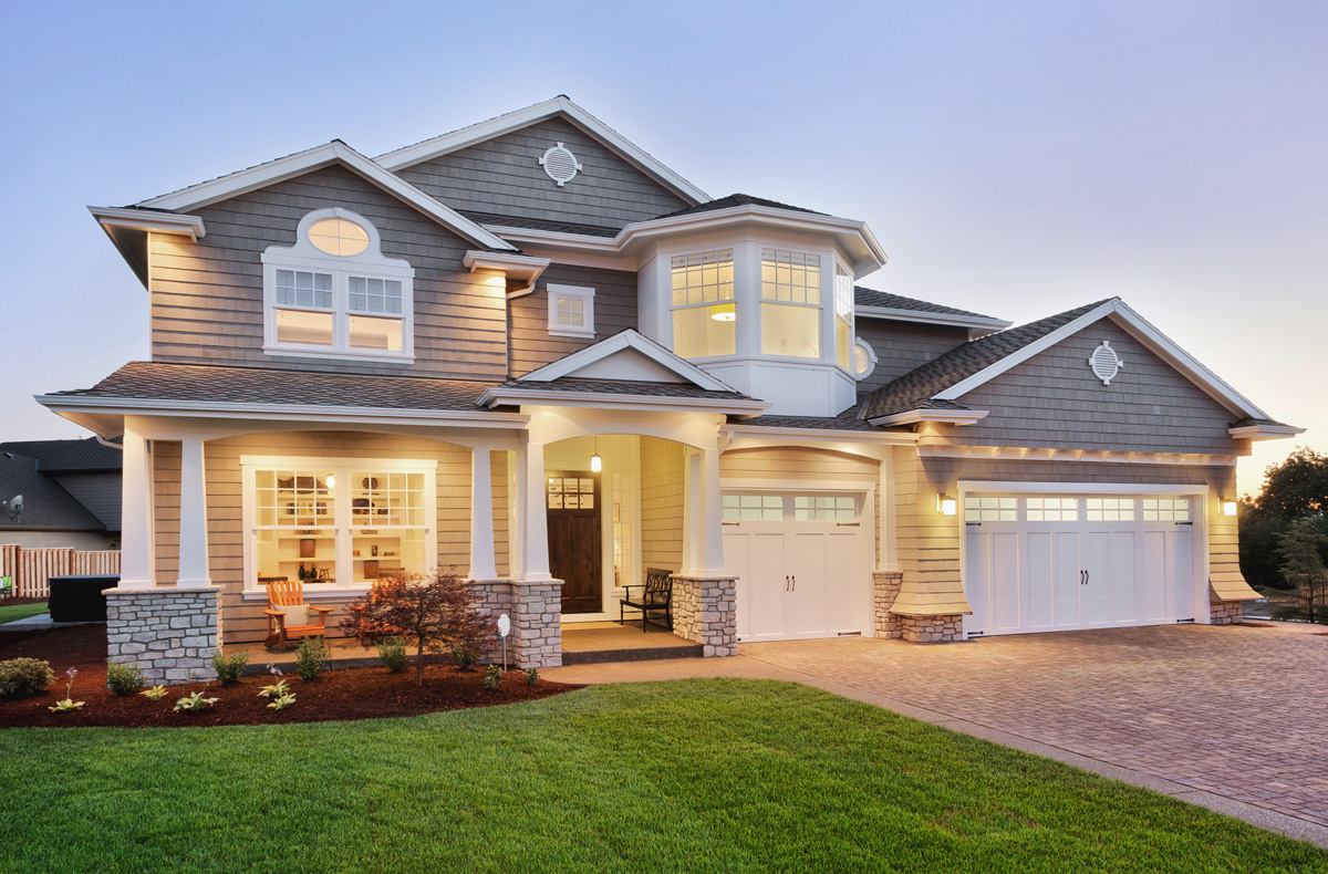 A large house with a lawn and garage.
