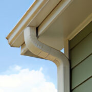 A close up of the corner of a house with a gutter