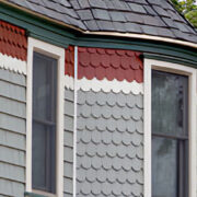 A house with many different colored shingles on the side of it.